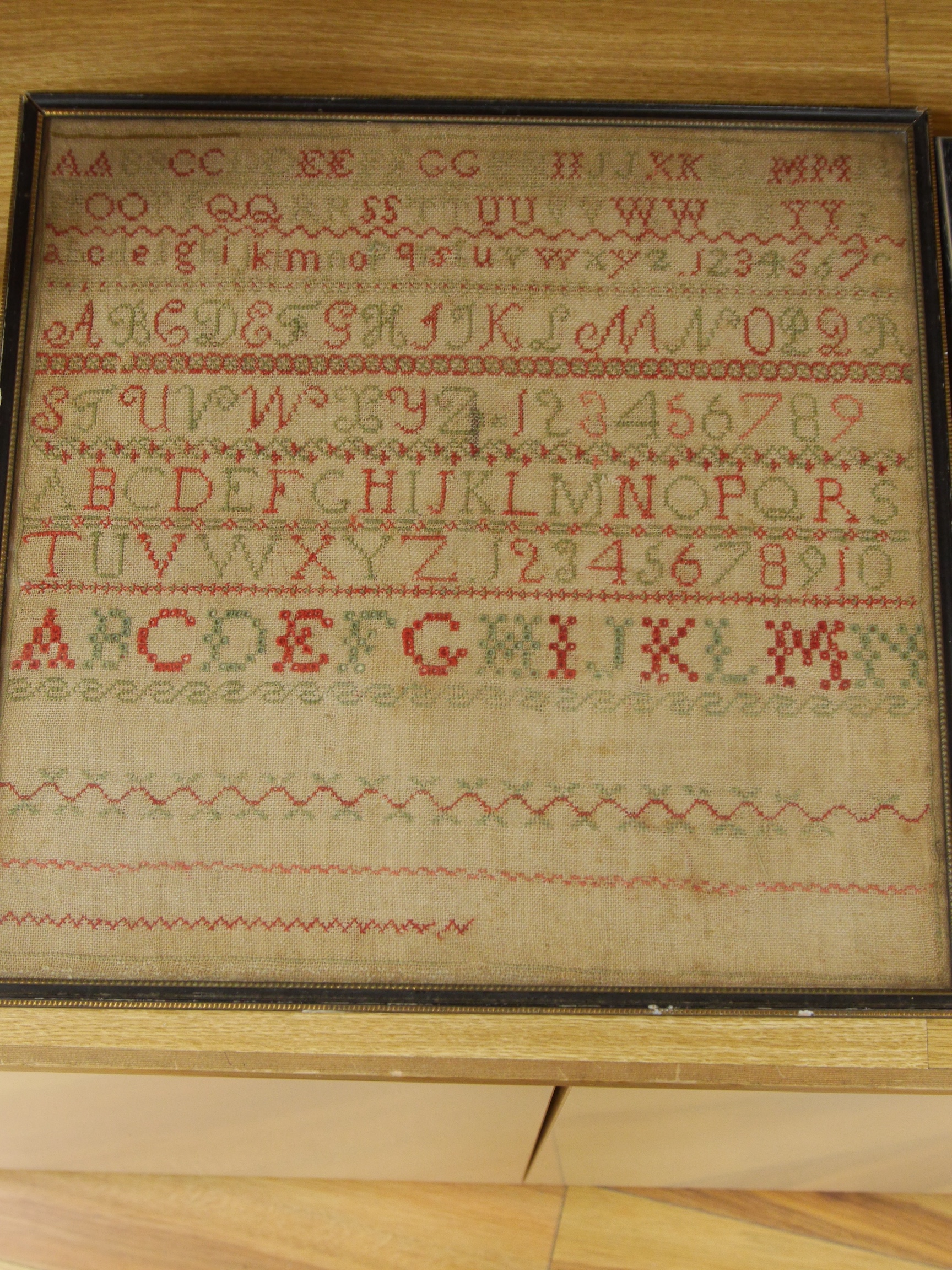 Three framed early to mid 19th century samplers, including an 1828 Adam and Eve sampler embroidered by Emma Parker, worked with a floral border with various spot motifs and verse, together with an alphabet sampler by Jan